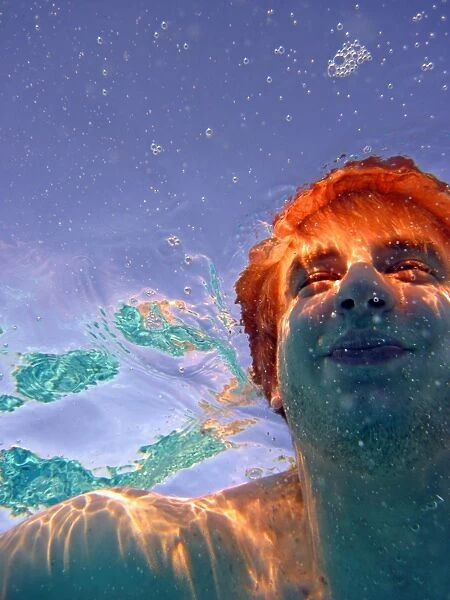 Man swimming underwater surrounded by bubbles