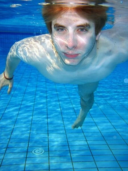 Man swimming underwater in a swimming pool