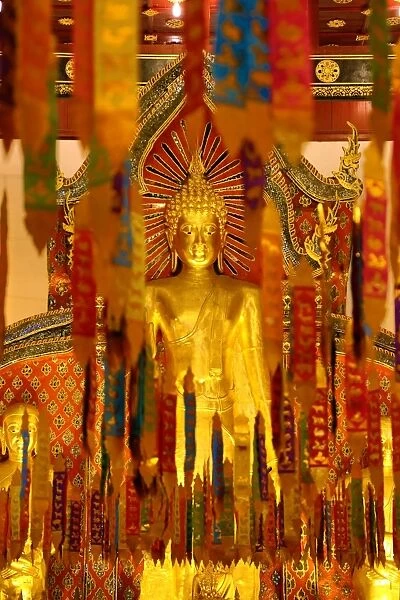 New Year banners and gold Buddha statue inside the Wat Chedi Luang Temple during Songkran in Chiang Mai, Thailand