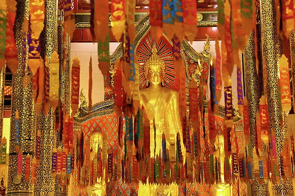 New Year banners and gold Buddha statue inside the Wat Chedi Luang Temple during Songkran in Chiang Mai, Thailand