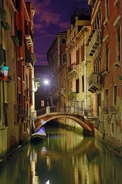 Night scene of a deserted bridge over a canal in Venice, Italy