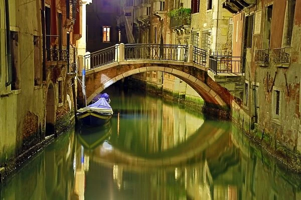 Night scene of a deserted bridge over a canal in Venice, Italy