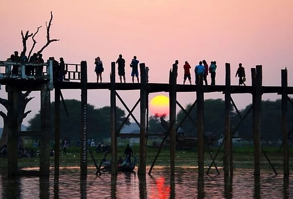 People crossing the U Bein Bridge at sunset, Amarapura, Myanmar