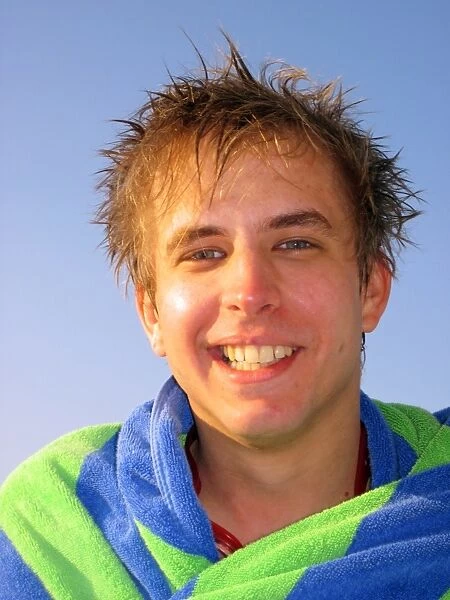 Portrait of a smiling man on summer holiday wrapped in a towel