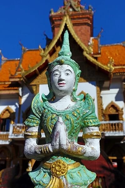 Praying statue in front of the ordination hall at Wat Buppharam Temple in Chiang Mai