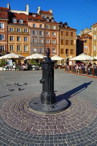Water pump and traditional houses in the Old Town Market Place in Warsaw, Poland