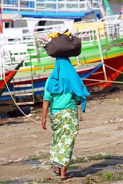 Woman carrying bag on her head in Old Bagan, Bagan, Myanmar (Burma)