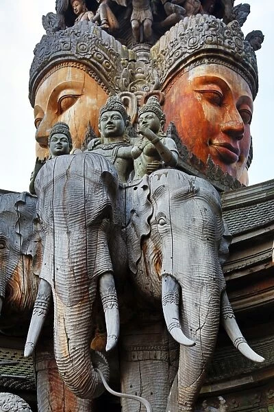 Wooden carving on the Sanctuary of Truth Temple, Prasat Sut Ja-Tum, Pattaya, Thailand showing a wood statue of a face and elephants