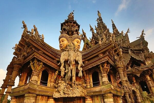 Wooden carving on the Sanctuary of Truth Temple, Prasat Sut Ja-Tum, Pattaya, Thailand showing a wood statue of faces and elephants