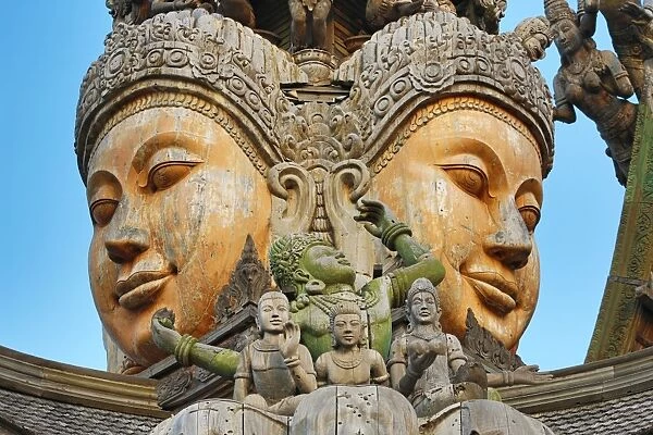 Wooden carving on the Sanctuary of Truth Temple, Prasat Sut Ja-Tum, Pattaya, Thailand showing a wood statue of faces