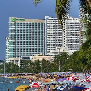Beach scene with umbrellas and hotels on the seafront of Pattaya, Thailand