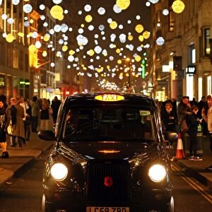 Black taxi cab with Oxford Street Christmas lights in London