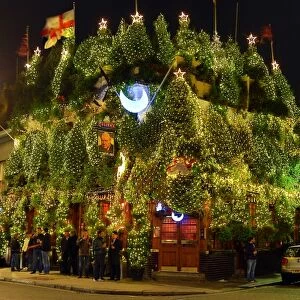Churchill Arms Pub covered in Christmas Trees in Kensington, London