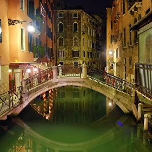 Deserted bridge over a canal at night in Venice, Italy