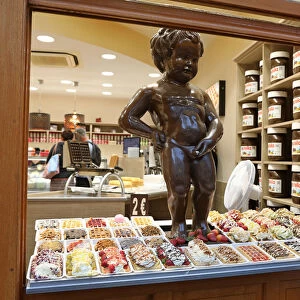 Model of the Manneken Pis, statue of a boy peeing, in the window of a waffle shop in Brussels