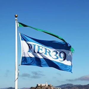Pier 39 flag, sightseeing boat and Alcatraz prison island in San Franciso, California