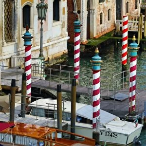 Red and white striped gondola mooring posts on the Grand Canal, in Venice, Italy