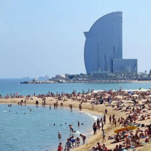 Scene of holiday crowds on the crowded beach and the W hotel, Barcelona, Spain