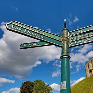 Tourist information signpost and Cliffords Tower at York Castle in York, Yorkshire
