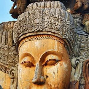 Wooden carving on the Sanctuary of Truth Temple, Prasat Sut Ja-Tum, Pattaya, Thailand showing a wood statue of a face