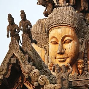 Wooden carvings on the Sanctuary of Truth Temple, Prasat Sut Ja-Tum, Pattaya, Thailand showing faces
