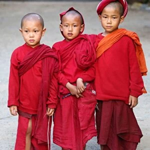 Three young Buddhist monks at a temple in Amarapura, Mandalay, Myanmar (Burma)