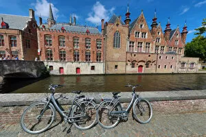 Bruges, Belgium Collection: Bicycles leaning against a canal wall with medievel buildings, Bruges, Belgium