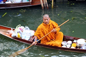 Buddhist Monk in a boat at Damnoen Saduak Floating Market, Ratchaburi near Bangkok, Thailand Buddhist Monk in a boat at Damnoen Saduak Floating Market, Ratchaburi near Bangkok, Thailand