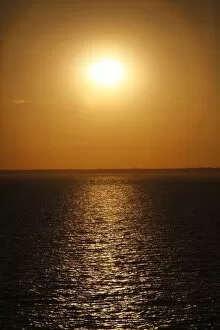Skies and Sunsets Collection: Golden sunset over the sea at dusk
