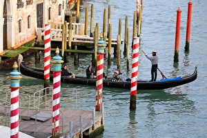 Gondola and Red and white striped gondola mooring posts on the Grand Canal, in Venice, Italy Gondola and Red and white striped gondola mooring posts on the Grand Canal, in Venice, Italy