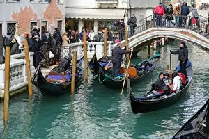 Images Dated 10th February 2013: Gondoleers poling gondolas carrying tourists along a canal, in Venice, Italy