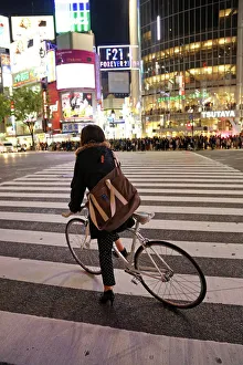 Japanese street scene showing crowds of people crossing the street and a cyclist on a pedestrian crossing in Shibuya Japanese street scene showing crowds of people crossing the street and a cyclist on a pedestrian crossing in Shibuya