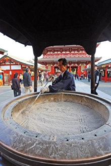 Man cleaning ashes in an incense burnder at the Sensoji Asakusa Kannon Temple, Tokyo, Japan Man cleaning ashes in an incense burnder at the Sensoji Asakusa Kannon Temple, Tokyo, Japan