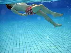 People Collection: Man swimming underwater in a swimming pool wearing goggles