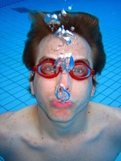 People Collection: Man swimming underwater wearing goggles blowing bubbles