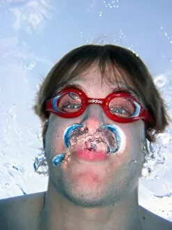 Images Dated 9th April 2011: Man swimming underwater wearing goggles blowing bubbles