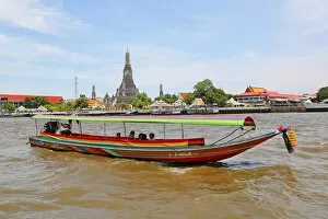 Images Dated 28th May 2013: Traditional Thai boat on the Chao Phraya River and Wat Arun, Temple of the Dawn, Bangkok, Thailand