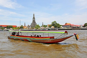 Traditional Thai boat on the Chao Phraya River and Wat Arun, Temple of the Dawn, Bangkok, Thailand Traditional Thai boat on the Chao Phraya River and Wat Arun, Temple of the Dawn, Bangkok, Thailand