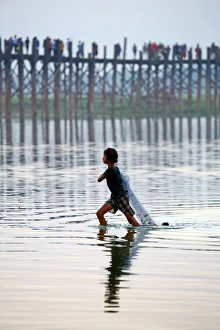 The U Bein Bridge with a fisherman walking across the Taungthaman Lake in Amarapura The U Bein Bridge with a fisherman walking across the Taungthaman Lake in Amarapura