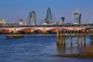 Wooden pier at Oxo Tower Wharf on the River Thames with Blackfriars Bridge and the City of London skyline in London Wooden pier at Oxo Tower Wharf on the River Thames with Blackfriars Bridge and the City of London skyline in London